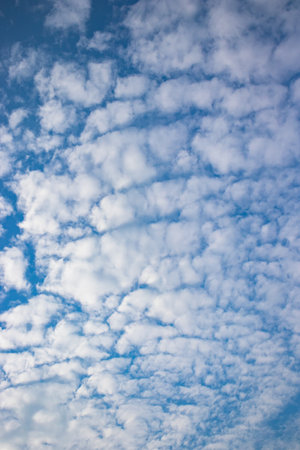 Tranquil landscape with clear blue sky, fluffy white clouds, and serene atmosphere.