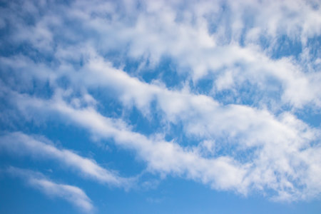 Clear blue sky, fluffy white clouds, peaceful natural landscape. Suitable for serene projects.の写真素材