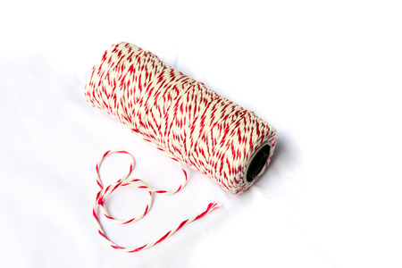 Red and white baker's twine spool on isolated background