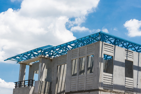 New home under construction using steel frames against cloudy skyの写真素材