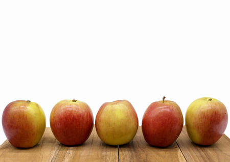 Five apple line up on wood block on white backgroundの写真素材