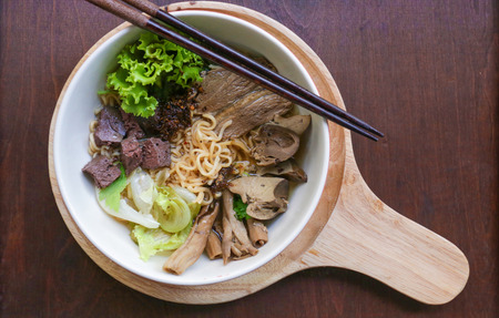 spicy duck noodle and veggie on wooden dish