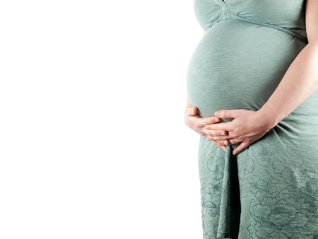 36 weeks pregnant young woman holding her belly over a white background