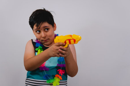 Child dressed in beach clothes, a blue tank top, a flower necklace on a white isolated background....