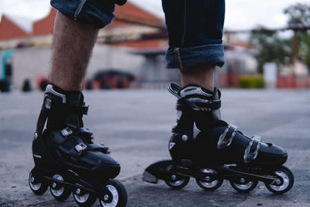 Close up of a pair of roller skates outside. The skates are black and white. Feet with skates on. High quality photoの写真素材