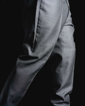 Gray pants on a black background. Fine fabric texture. Elegant suit pants. High quality photoの写真素材