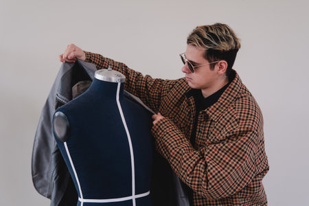 Fashion designer placing clothes on a mannequin. Designer working on a new clothing item. High quality photoの写真素材
