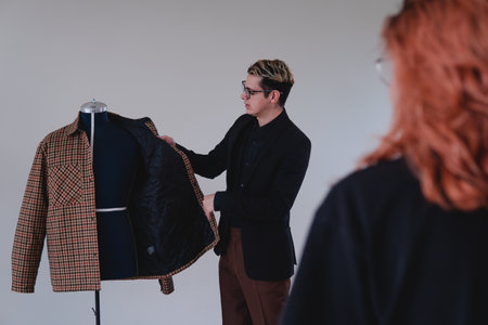 Tailor placing a suit on a mannequin. Fashion designer working on an elegant yellow suit. High quality photoの写真素材