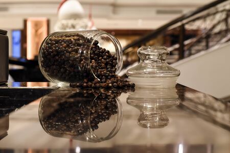 Dried juniper berry are in glass bottle with reflection in the mirror
