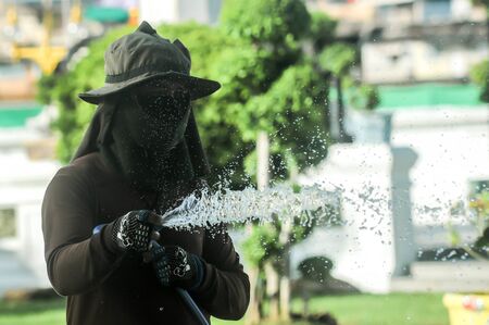 The garden man splash water in the park at Wat Arun,Bangkok Thailandの写真素材