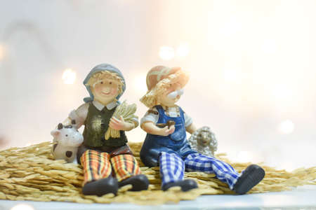 Couple grandparent dolls sit on the ear of rice with blur backgroundの写真素材