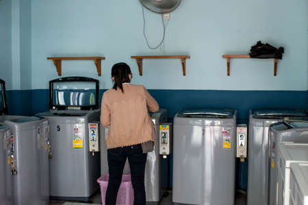 May 19,2020 The backside of an Asian girl at self-service coin washing machine LG brand area at a...
