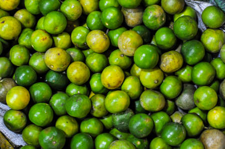 Fullframe background texture of fresh green limes at Bangkapi outdoor fresh market in Bangkok Thailandの写真素材