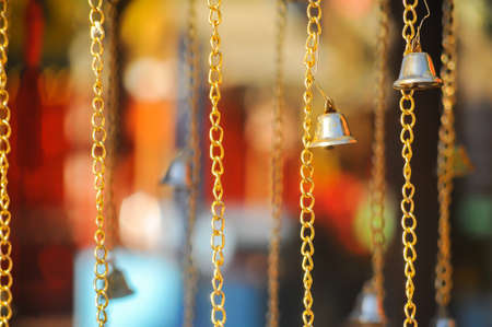 The small golden bells have been hanging near The Church at Wat Indharaviharn temple in Bangkok Thailandの写真素材