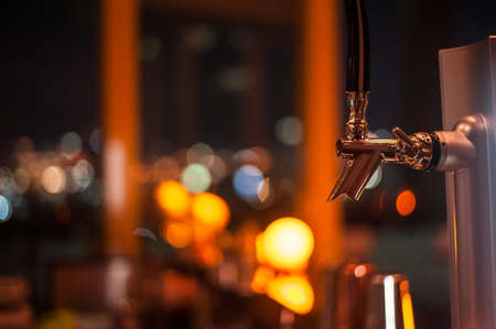 The beer faucet with bokeh background in the night club in Bangkok Thailandの写真素材