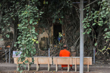 September 18, 2020 The Backside of Monk sat on a chair near the ancient church with notice board (Not allowed to sit on the window) at Wat Bang kung Temple in SamutSongkhram province,Thailandのeditorial素材