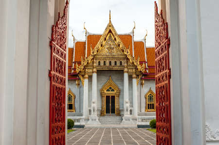 Wat Benchamabophit Dusitwanaram or the Marble temple through by the curved steel open door in...