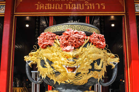 The Big joss-stick pot as Dragon style behind with a signboard in Thai language ( Wat Samananam...
