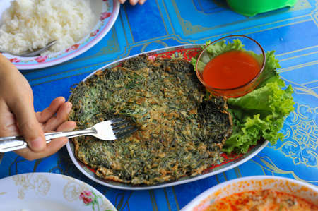 Top view of Authentic Thai style omelet with Suaeda Maritima leaves  (The Local food ) eat with ketchup at Wat Khun Samut Chin temple, Samut Prakan province, Thailandの写真素材