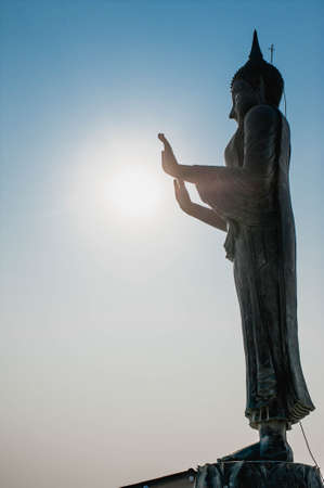 The silhouette view of Standing Buddha in The attitude of stopping the rainstorm in front of the Gulf of Thailand at Wat Khun Samut Chin temple, Samut Prakan province, Thailandの写真素材