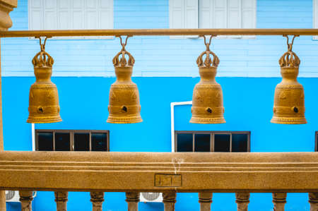 The hanging Golden bells with blue background at Wat Sakhala temple in Samutprakan province ,Thailandの写真素材