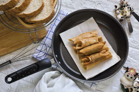 Top view of Thai style homemade Roll pancake stuffed with pork and custard or thai name " Ka nom Tokyo"  on a black pan in Bangkok, Thailandの写真素材