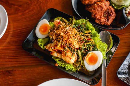 Thai style sweet and spicy water mimosa salad with shrimps and boiled eggの写真素材