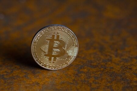 golden bitcoin coin close-up with rusty background