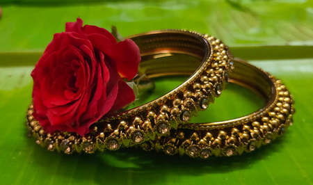 Indian traditional jewellery bangle set on a banana leaf with rose