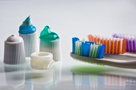 Colorful toothpaste squeezed onto their caps with toothbrushes and flossの写真素材