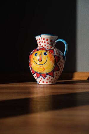 Ceramic beautiful painted vase with handle and sun motive onの写真素材