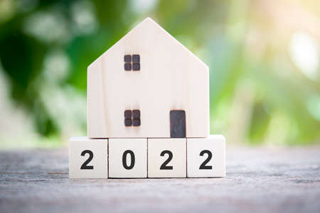 House model standing on wood block number 2022 concept for new house, new year property, property concept isolated on sunlight bokeh background.の写真素材