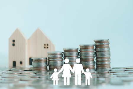Stacking of money coins and paper family on wooden table for donation, saving, charity, family finance plan concept, fundraising, superannuation, financial crisis concept.の写真素材