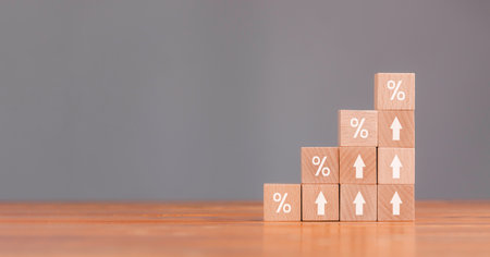 Wooden blocks with Icon percentage symbol and arrow pointing up with concept for Interest rate financial and mortgage rates. The economy is improving.の写真素材