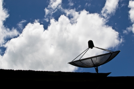 Satellite dish on the roof with blue skyの写真素材