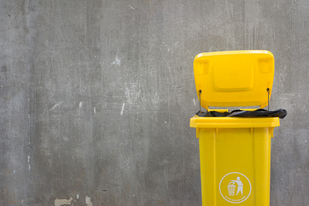 Trash yellow with gray plaster walls.の写真素材