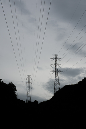 Silhouette of high voltage poles on the mountain.の写真素材