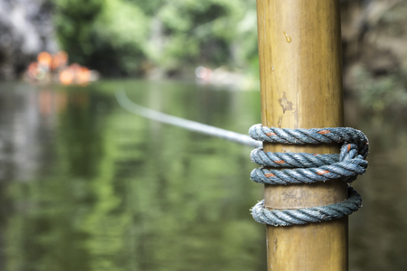 Nylon green rope holds the raft touring with bamboo poles.の写真素材