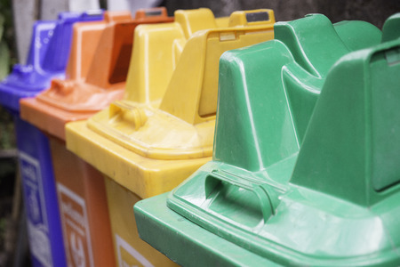 The four trash bins are separated by colors and items left in the trash.の写真素材