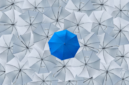 A normal blue umbrella is different from the overturn grey umbrellas, Being different concepts, Business concept, Leader, Blue umbrella can protect rain, grey umbrellas can't protect rain, Top view.の写真素材