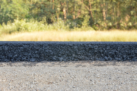 Cross section of asphalt road with blury green trees background.の写真素材