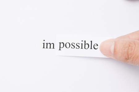 Possible Concept. Changing The Word Impossible to Possible. Seperate word im and possible.  hand holding possible words. word im on white paper. Focus at text or words.の写真素材