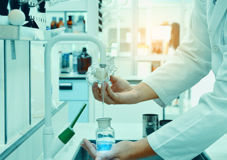 Scientists collect water samples in laboratory with light. Science concept.