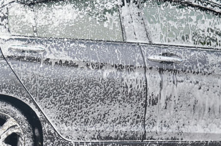 Car wash with foam in car wash stationの写真素材