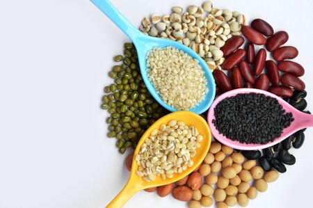 Cereal grains ,seeds, beans with black sesame, white sesame and barley in plastic spoon. Group of mung bean, groundnut, soybean, millet, black bean and red bean. isolated on white background.の写真素材