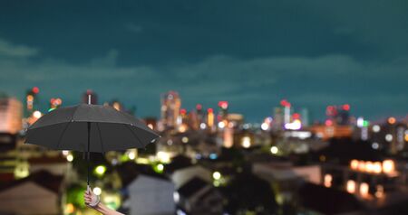The black umbrella in city night light bokeh backgroundの写真素材