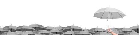 Leadership business concept: Black umbrella over gray umbrellas white backgroundの写真素材