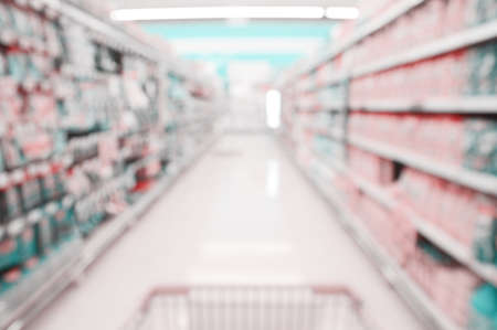 Blurred background of consumption shelves and shopping cart in the supermarket, out of focus banner, Department store backdrop.の写真素材