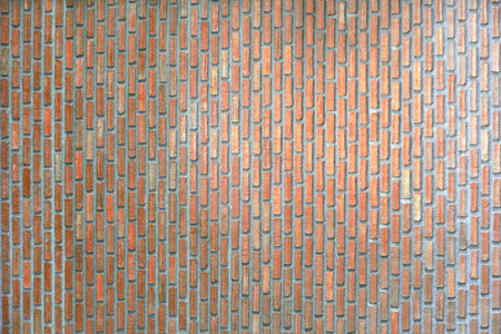 Red brick wall texture background with weathered bricks and cement joints with light on its surface