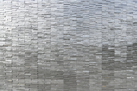 Black tile wall background texture panorama long photo dark fence wall with black brick with concrete modern home decoraction grey stone marble with light on surface.の写真素材